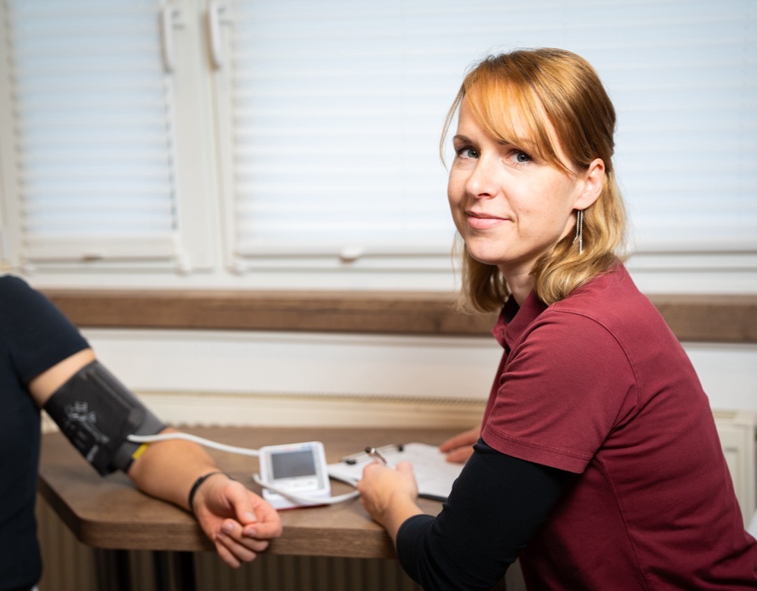 Mitarbeiterin bei der Blutdruckmessung