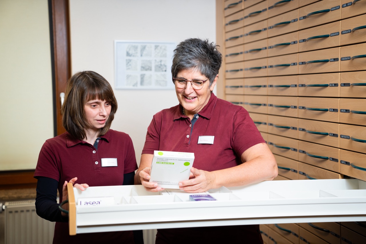 Zwei Mitarbeiterinnen vor einer offenen Schublade im Lager