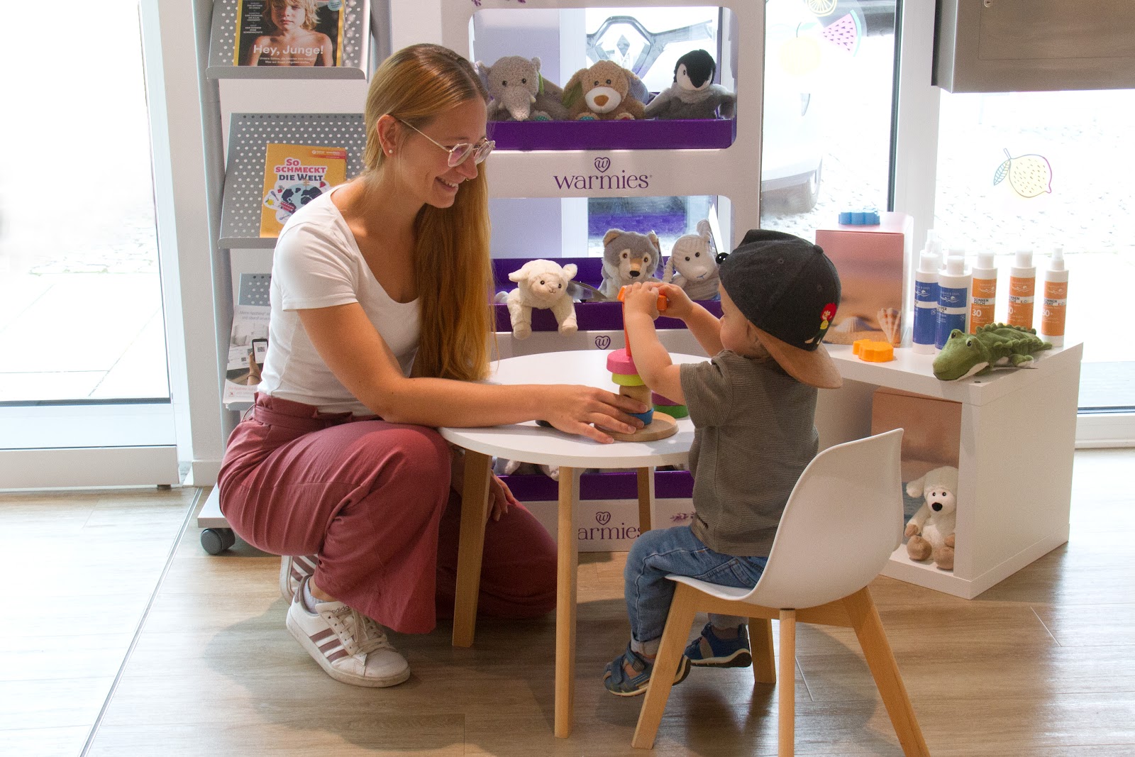 Mutter und ihr Kind in der Spielecke der Apotheke