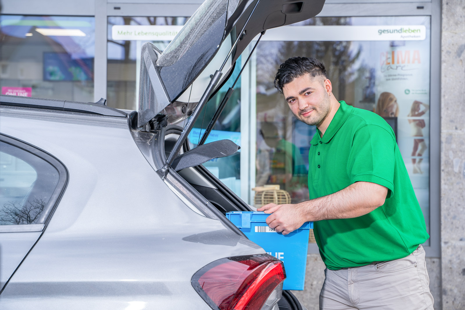 Lieferant läd eine Bestellung in den Kofferraum des Lieferautos