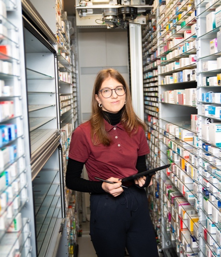 Eine Mitarbeiterin mit Klemmbrett im Lager