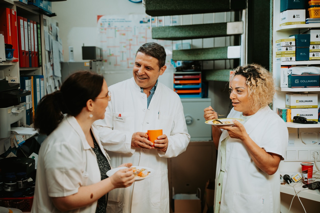 Inhaber mit zwei Kolleginnen im Austausch beim Kaffeetrinken