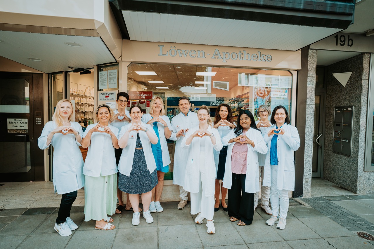 Das Team der Löwen Apotheke formt mit den Händen ein Herz