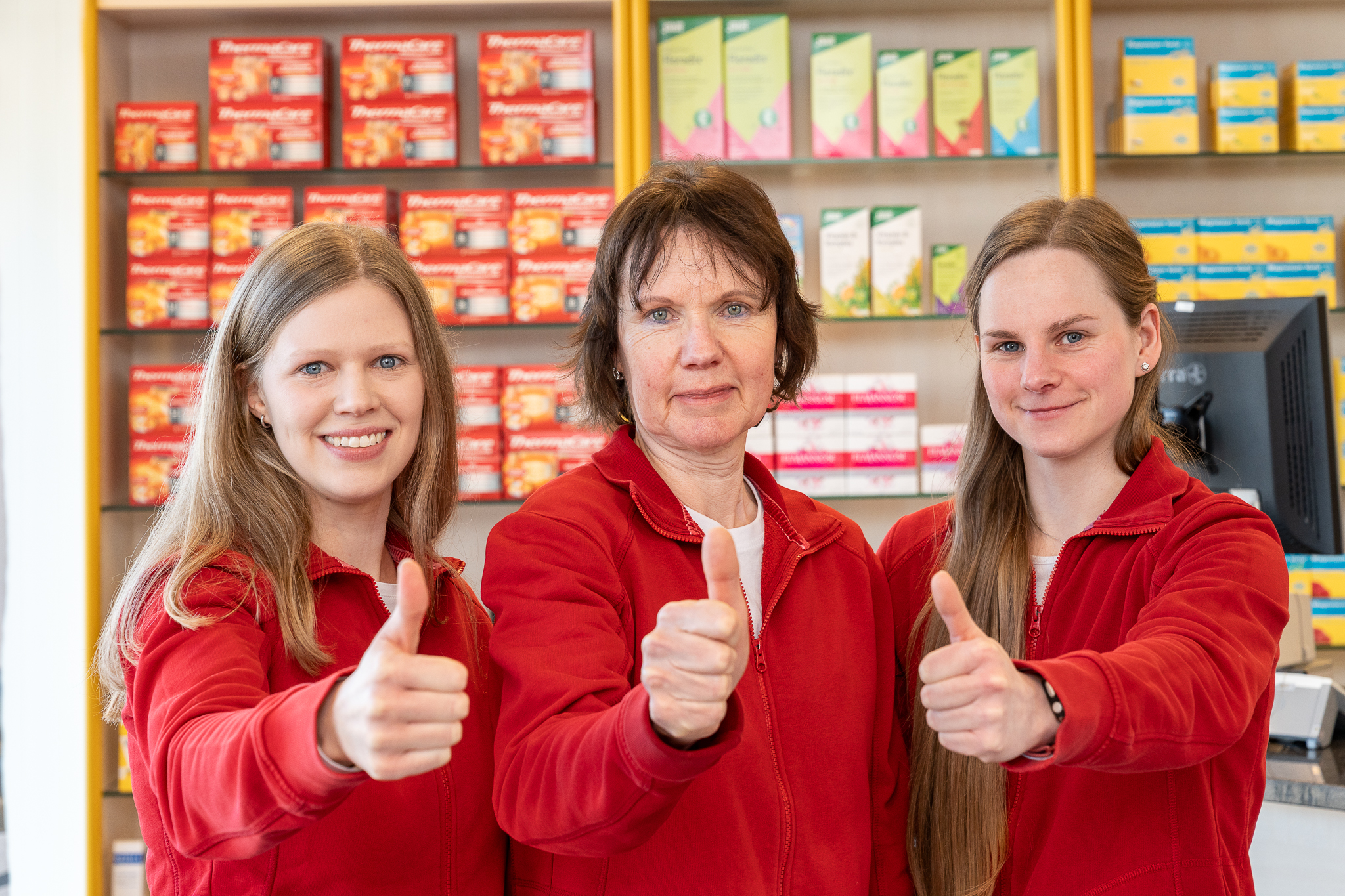Drei Mitarbeiterinnen zeigen mit dem Daumen nach oben