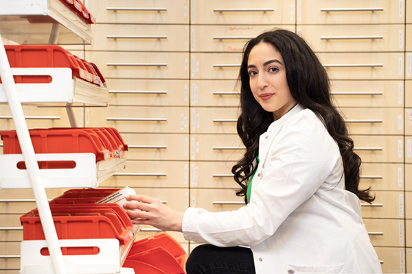 Mitarbeiterin beim Einsortieren von Medikamenten