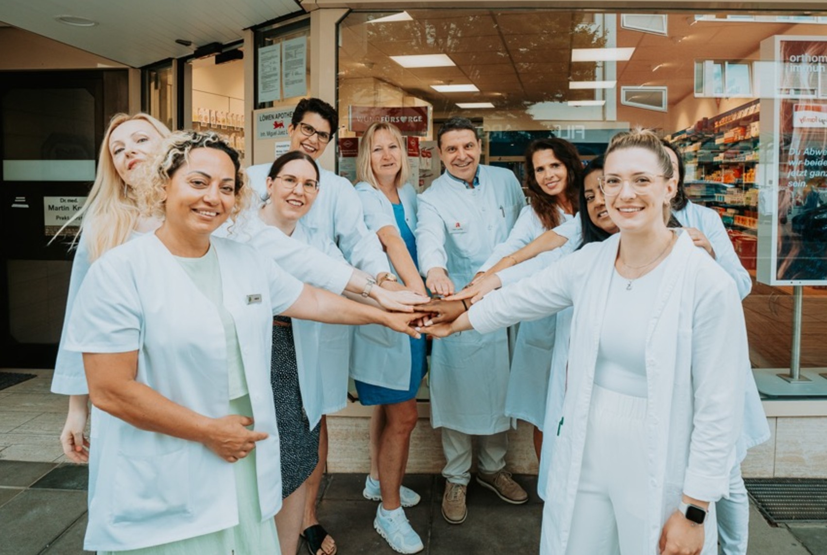 Das Team der Löwen Apotheke Degerloch mit den Händen aufeinander