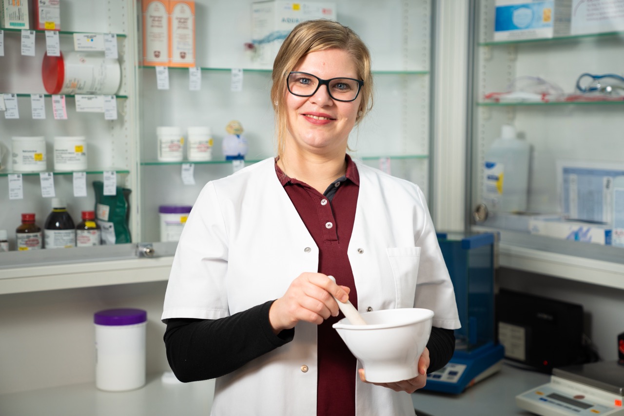 Eine PTA im Labor hält einen Tegel in der Hand