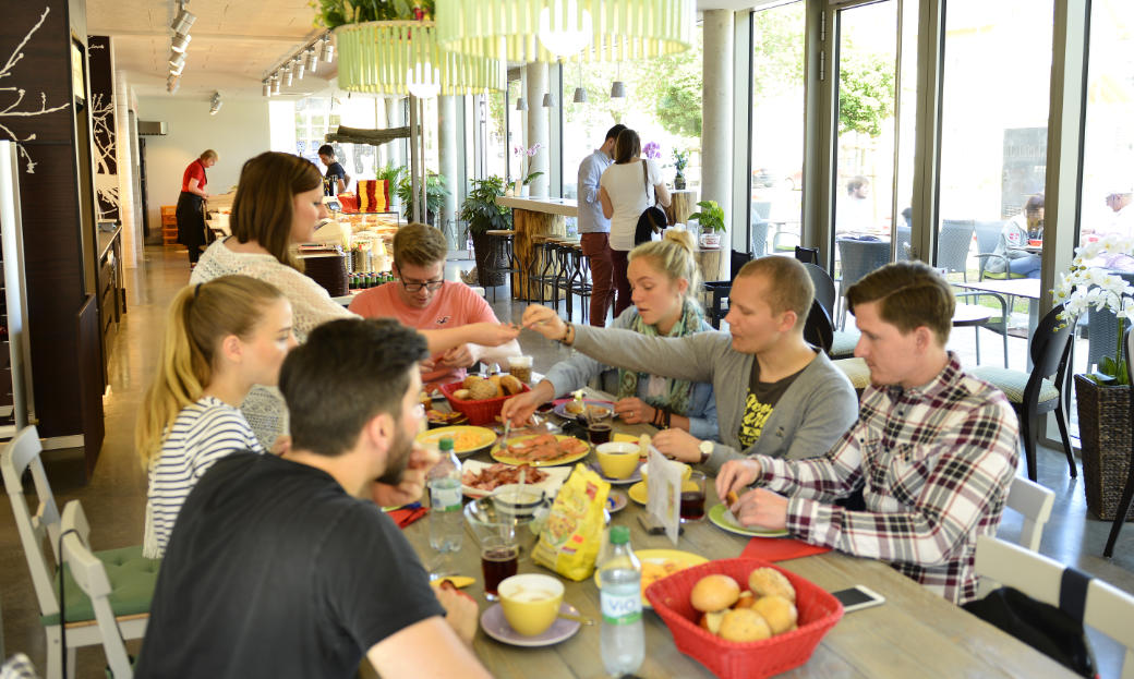 Gruppe von Menschen beim morgendlichen Frühstück im Cafe Das Backparadies