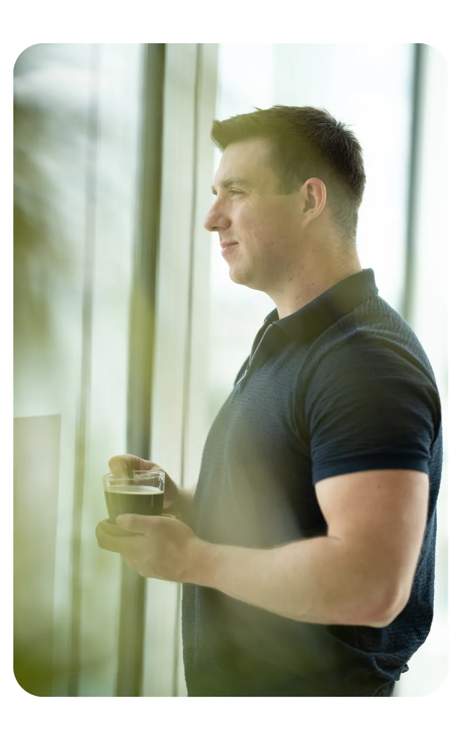 Marcel Scholz am Fenster mit einer Tasse in der Hand