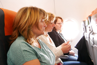 Teilnehmer bei einem Seminar mit Flug im Flugzeug sitzend