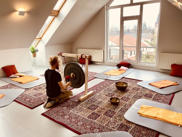 Paul Bratfisch sitz bei einer Gongentspannung vor dem Buckelgong im Freiraum Panketal