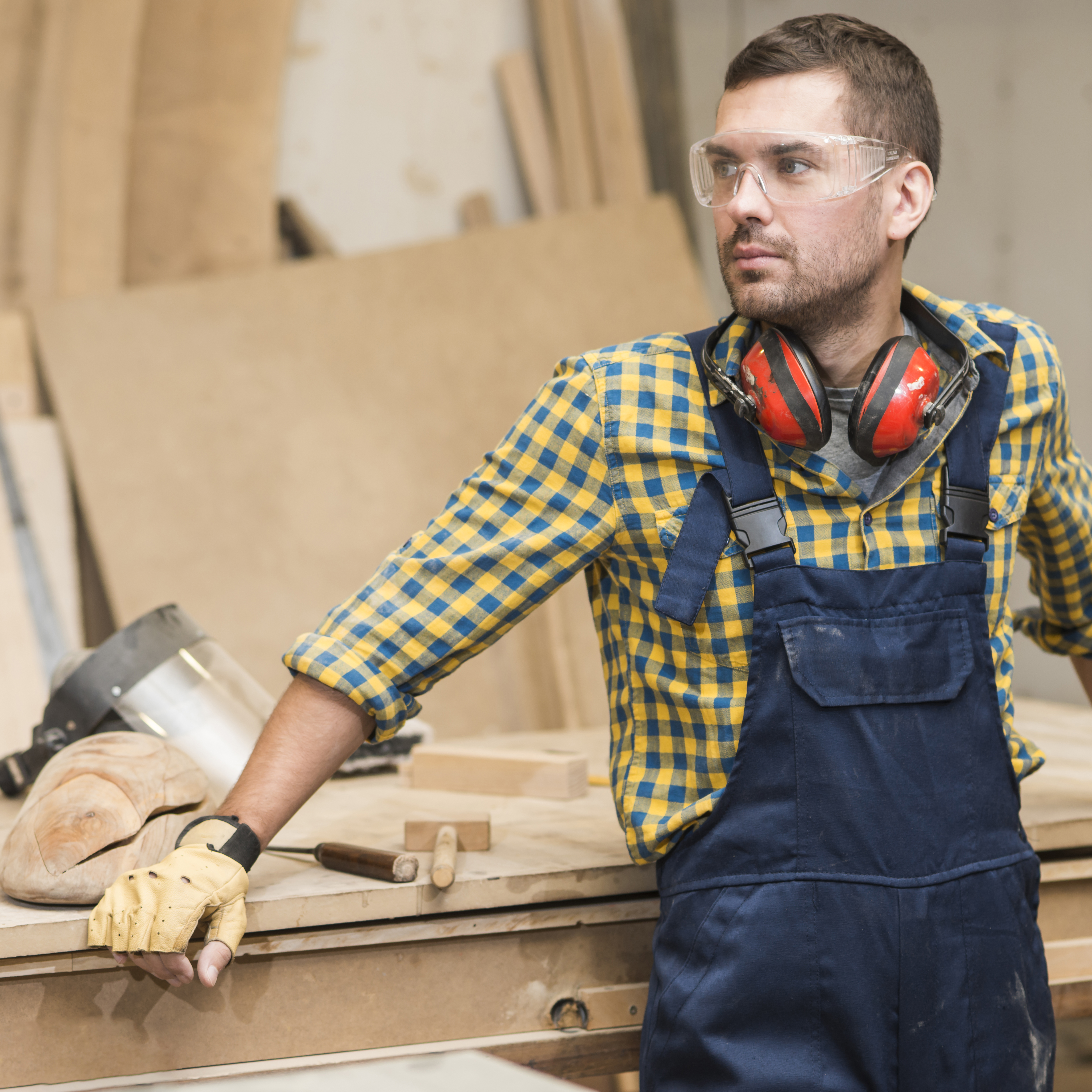 male-carpenter-standing-front-workbench-looking-away.jpg