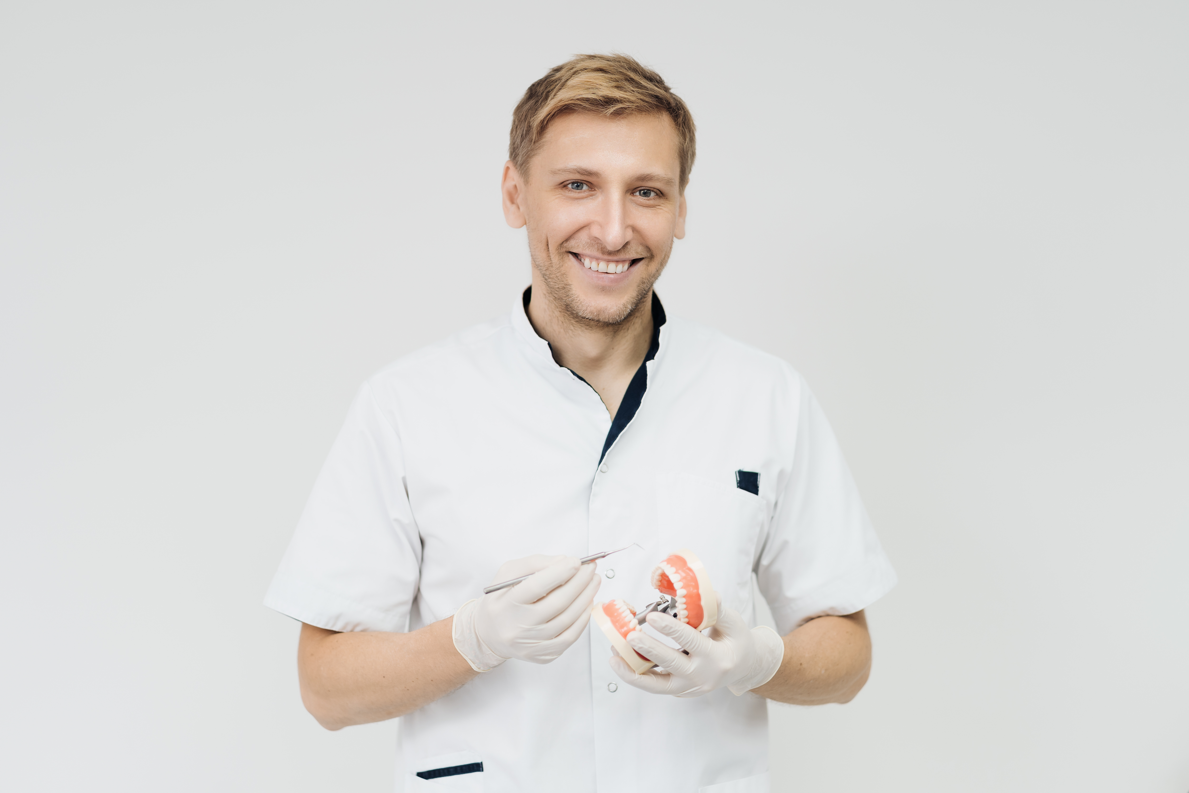 stomatologist-doctor-explaining-proper-dental-hygiene-patient-holding-sample-human-jaw.jpg