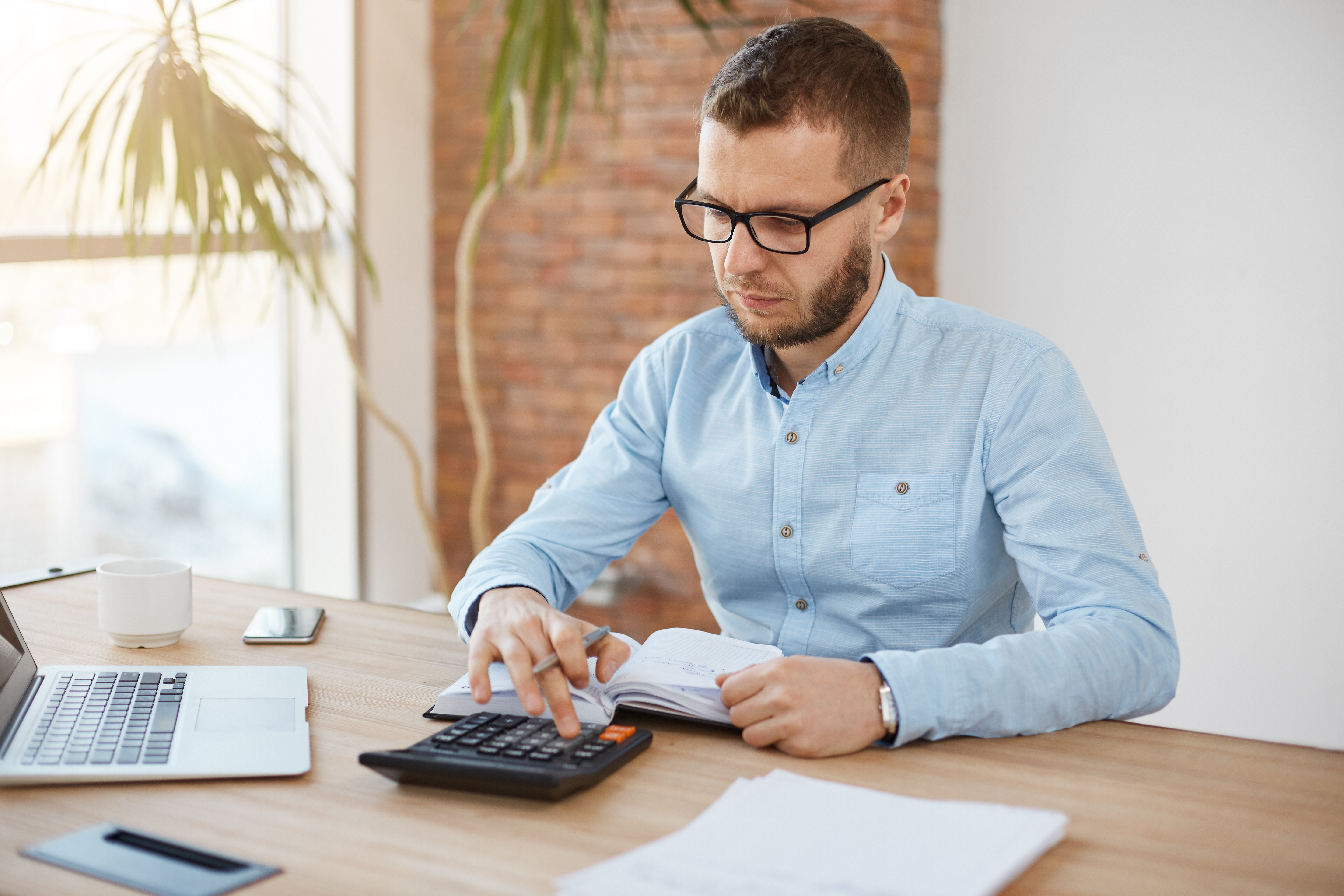 adult-serious-bearded-caucasian-finance-manager-glasses-blue-shirt-sitting-light-comfortable-company-office.jpg