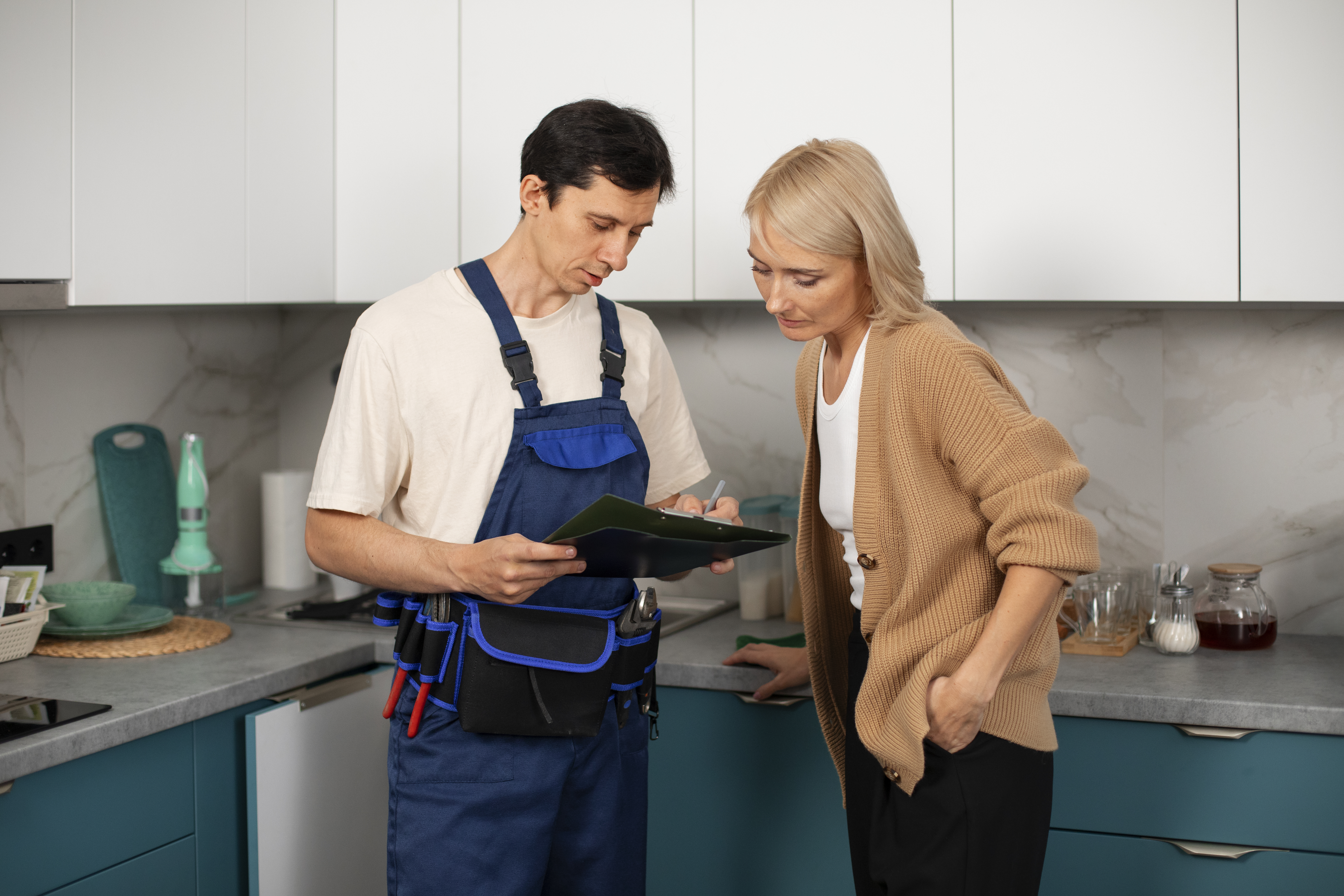 male-plumber-working-with-client-fix-kitchen-problems.jpg