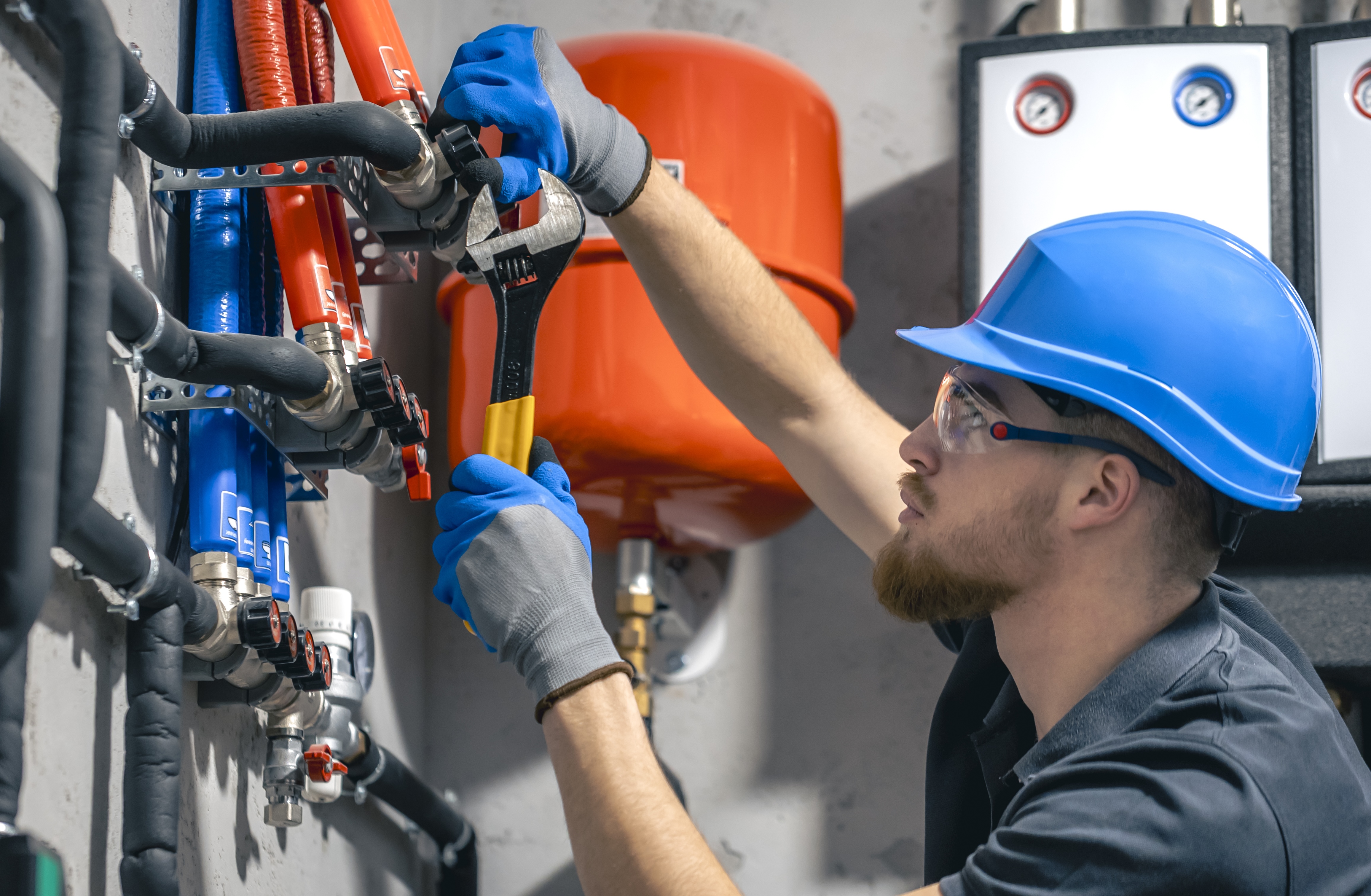 man-installs-heating-system-house-checks-pipes-with-wrench.jpg