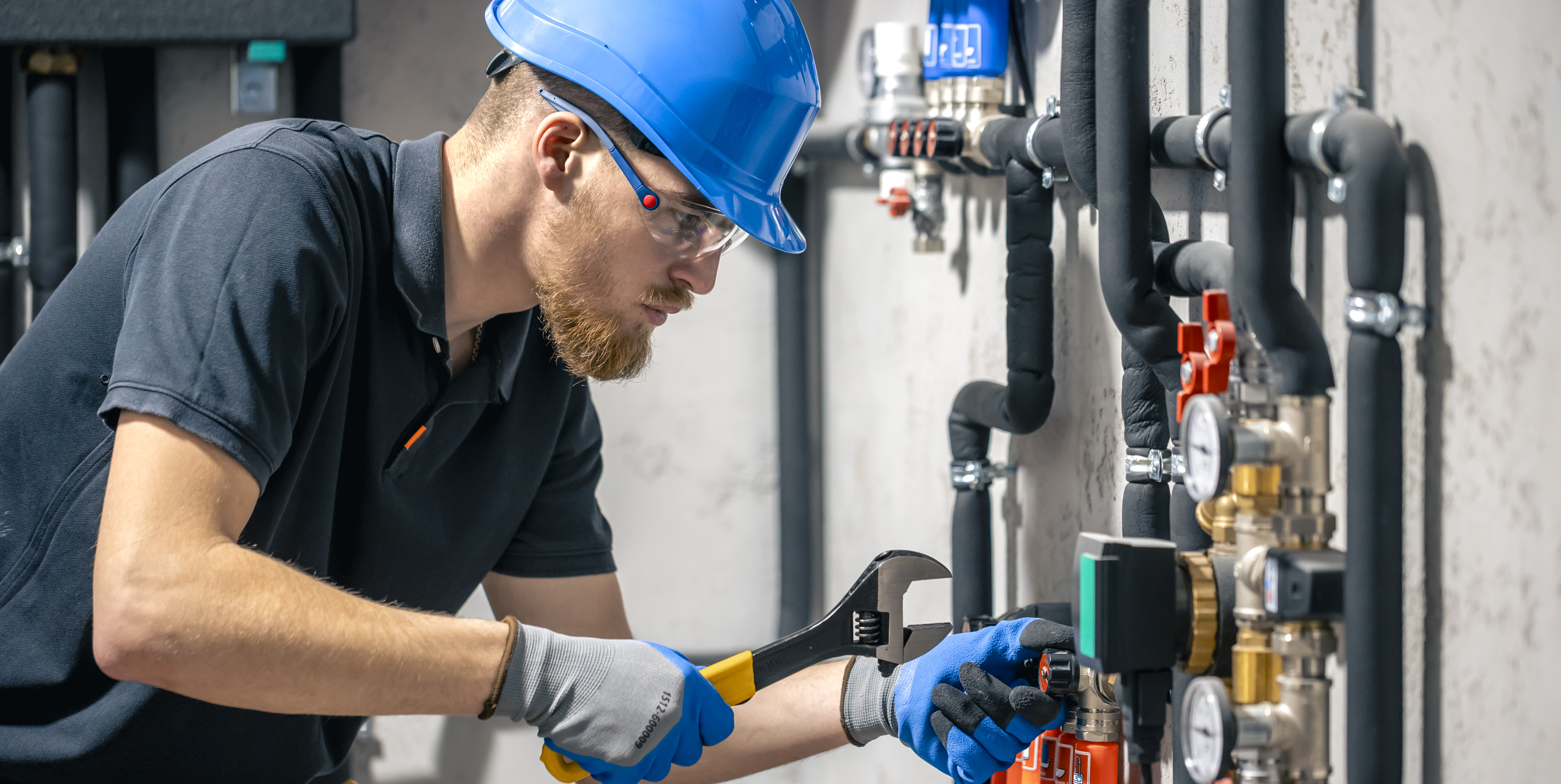 man-installs-heating-system-house-checks-pipes-with-wrench.jpg