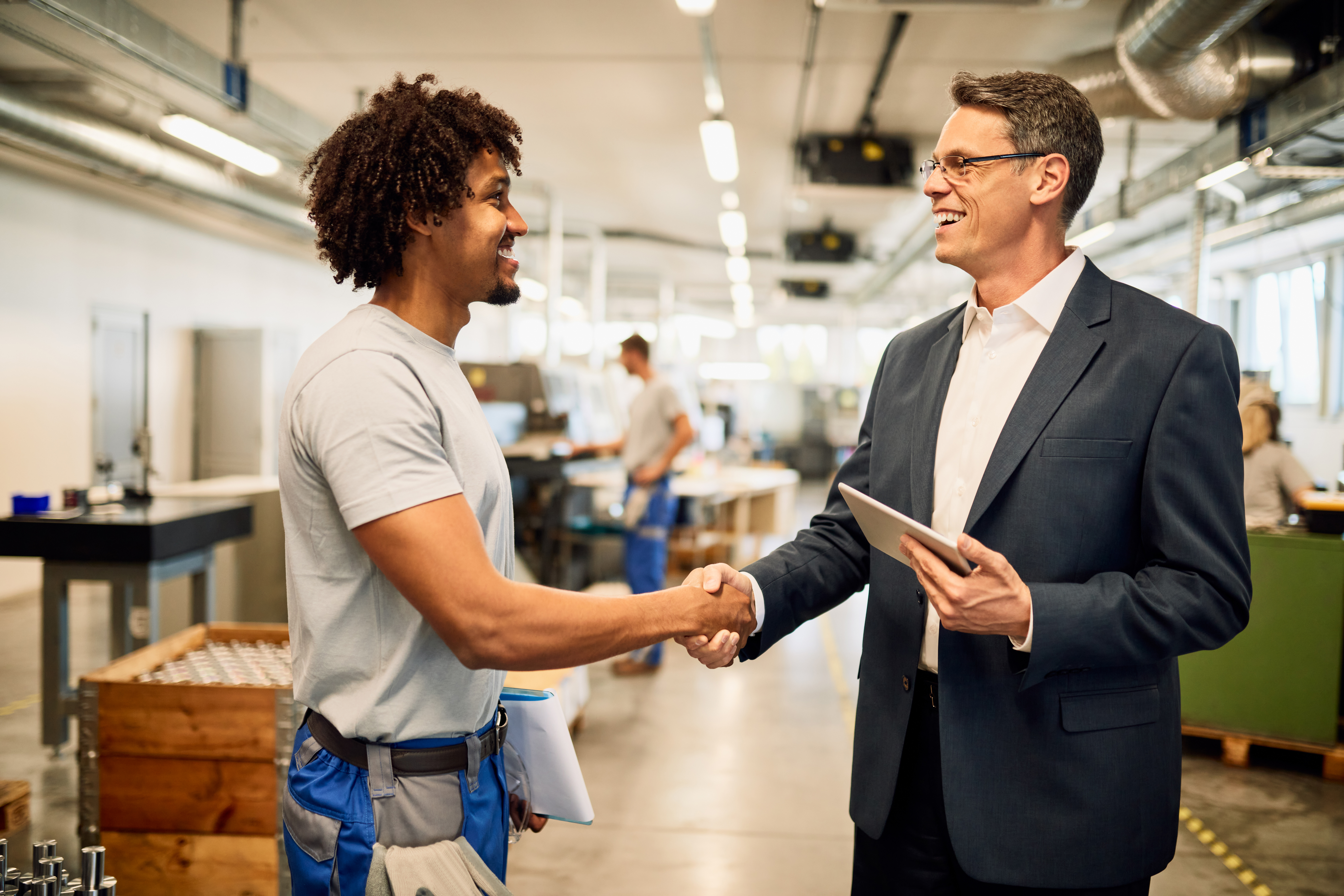 happy-engineer-young-black-worker-handshaking-while-greeting-industrial-building.jpg