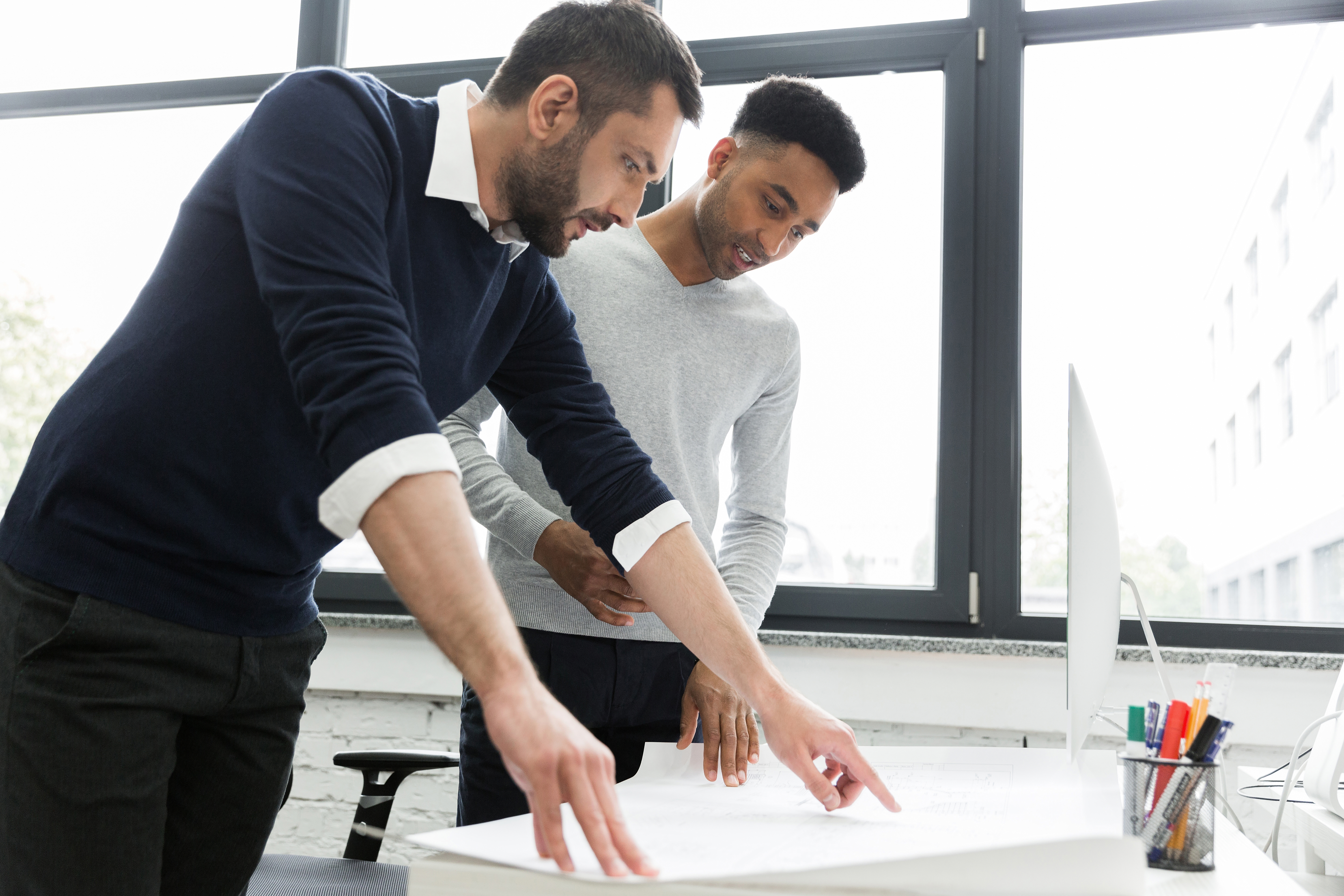 two-young-male-office-workers-pointing-chart.jpg