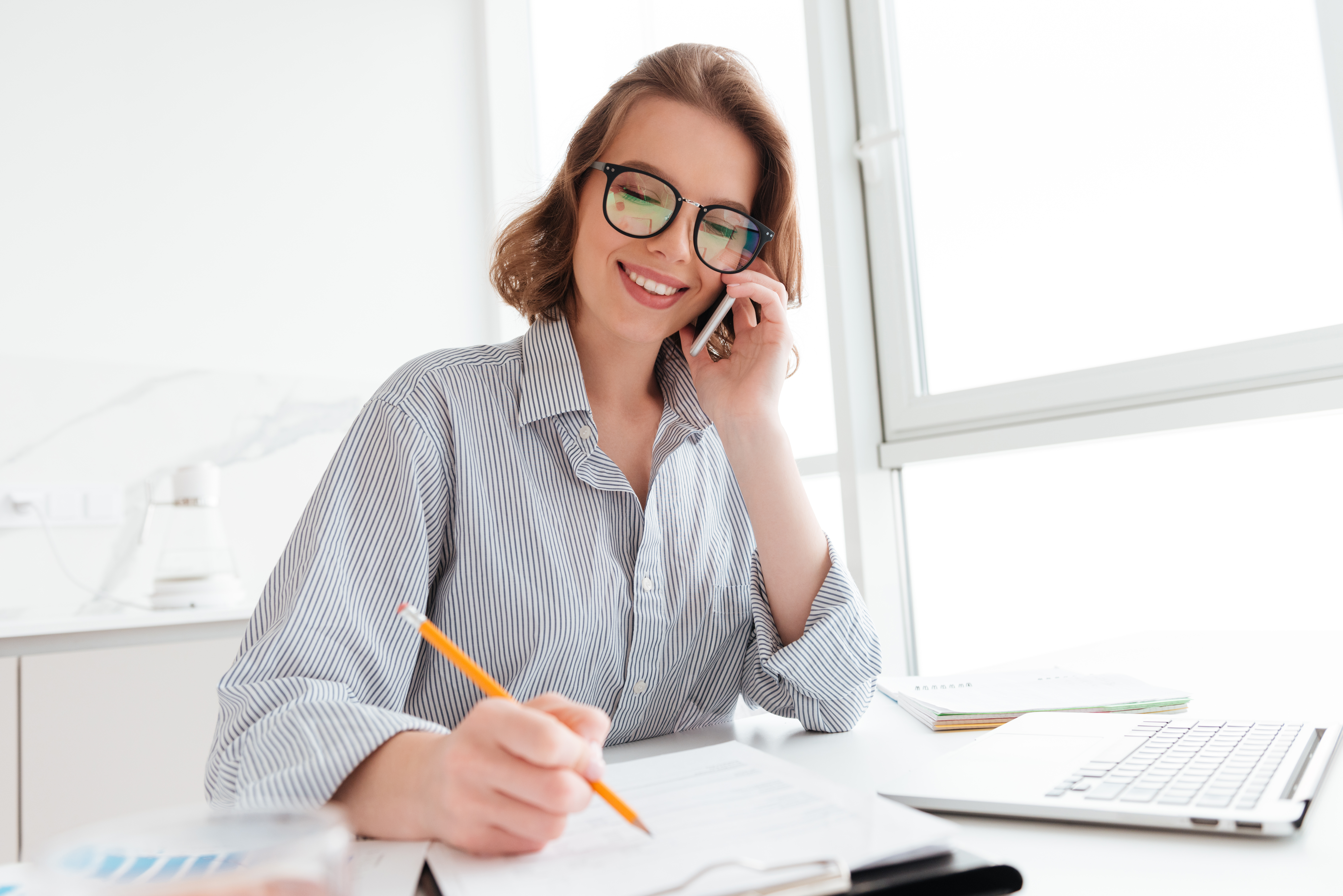 beautiful-smiling-woman-glasses-talking-mobile-phone-while-working-with-documents-home.jpg