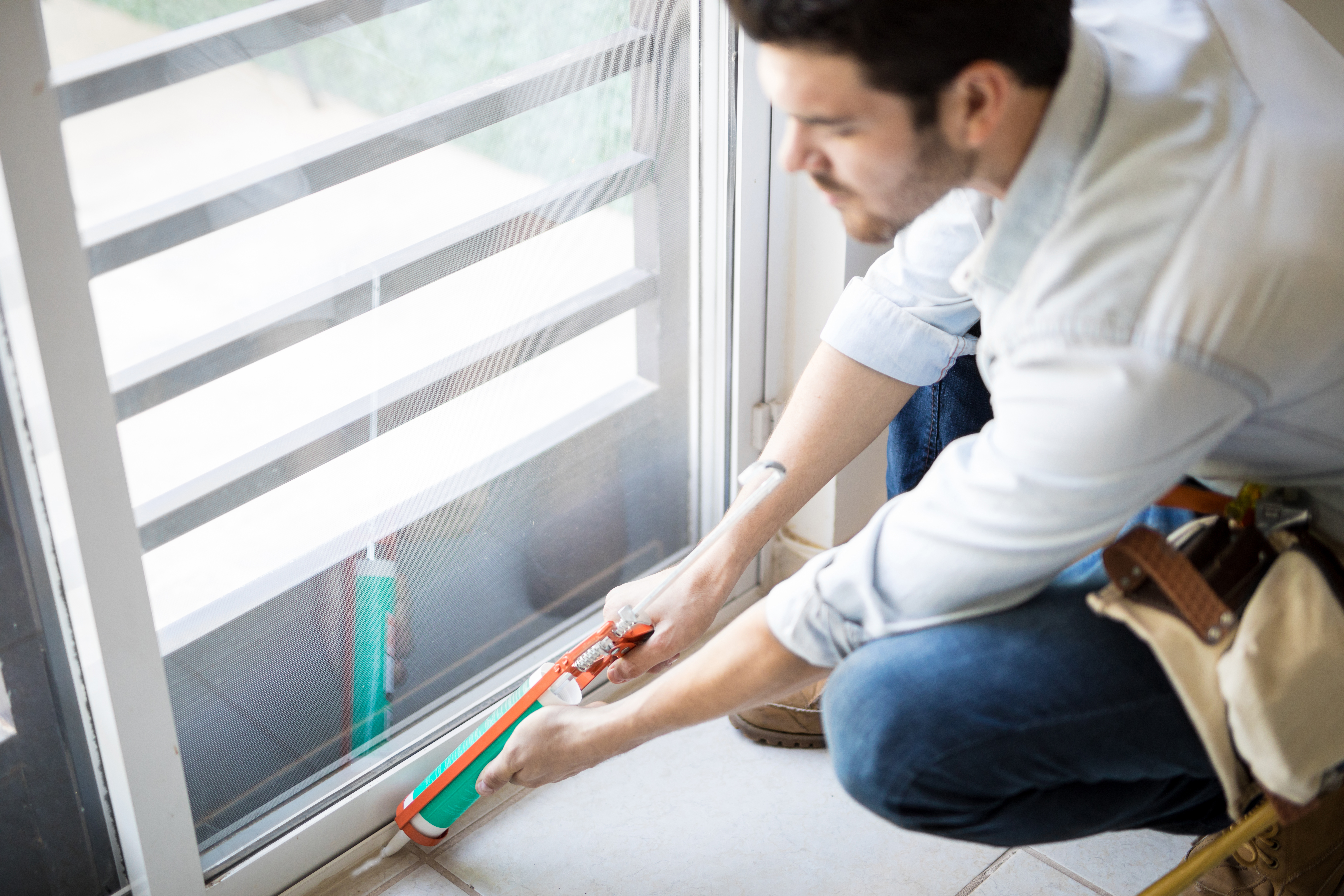 closeup-young-handyman-applying-some-sealant-door-with-sealing-gun.jpg