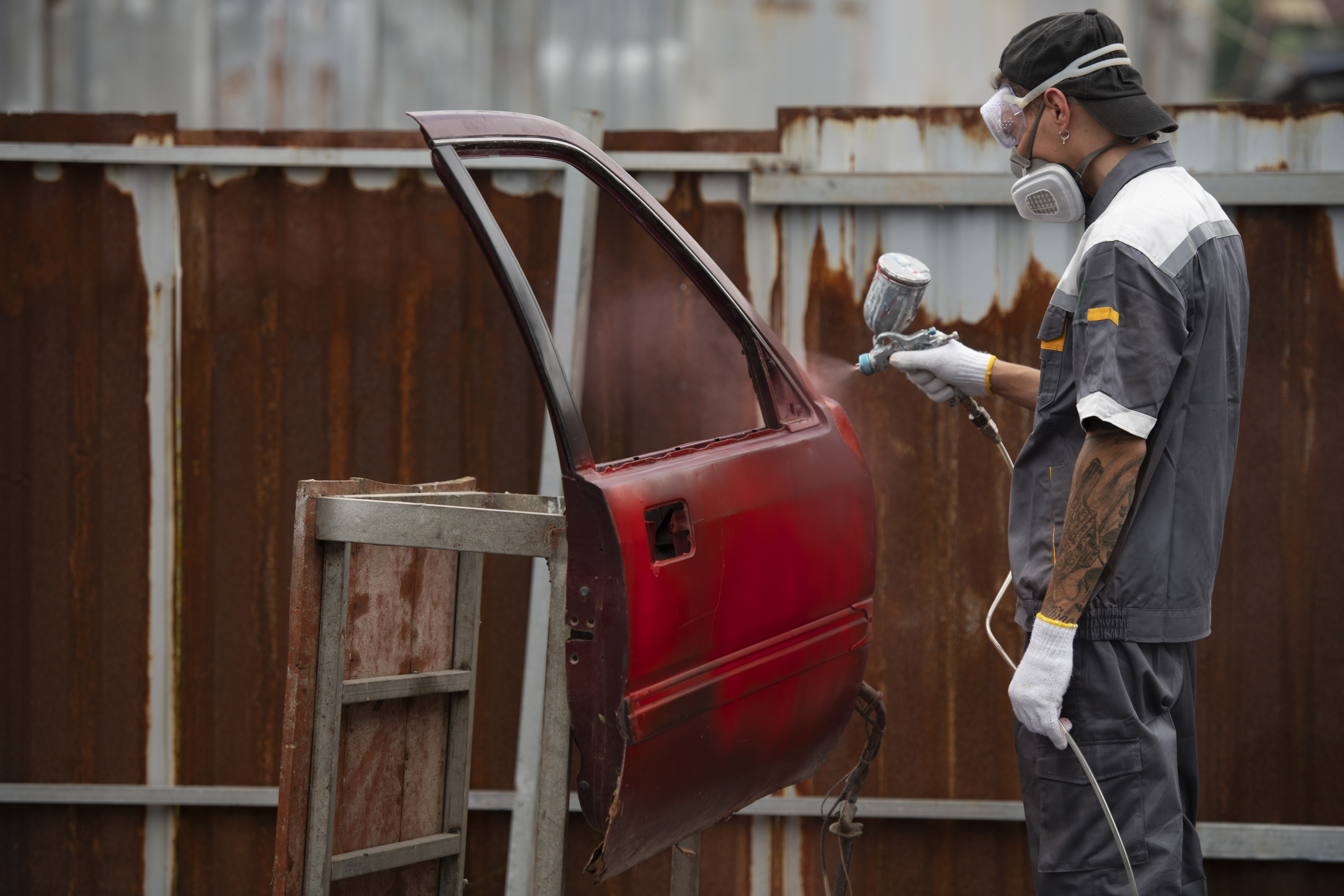 medium-shot-man-spraying-powder-paint-car-door.jpg
