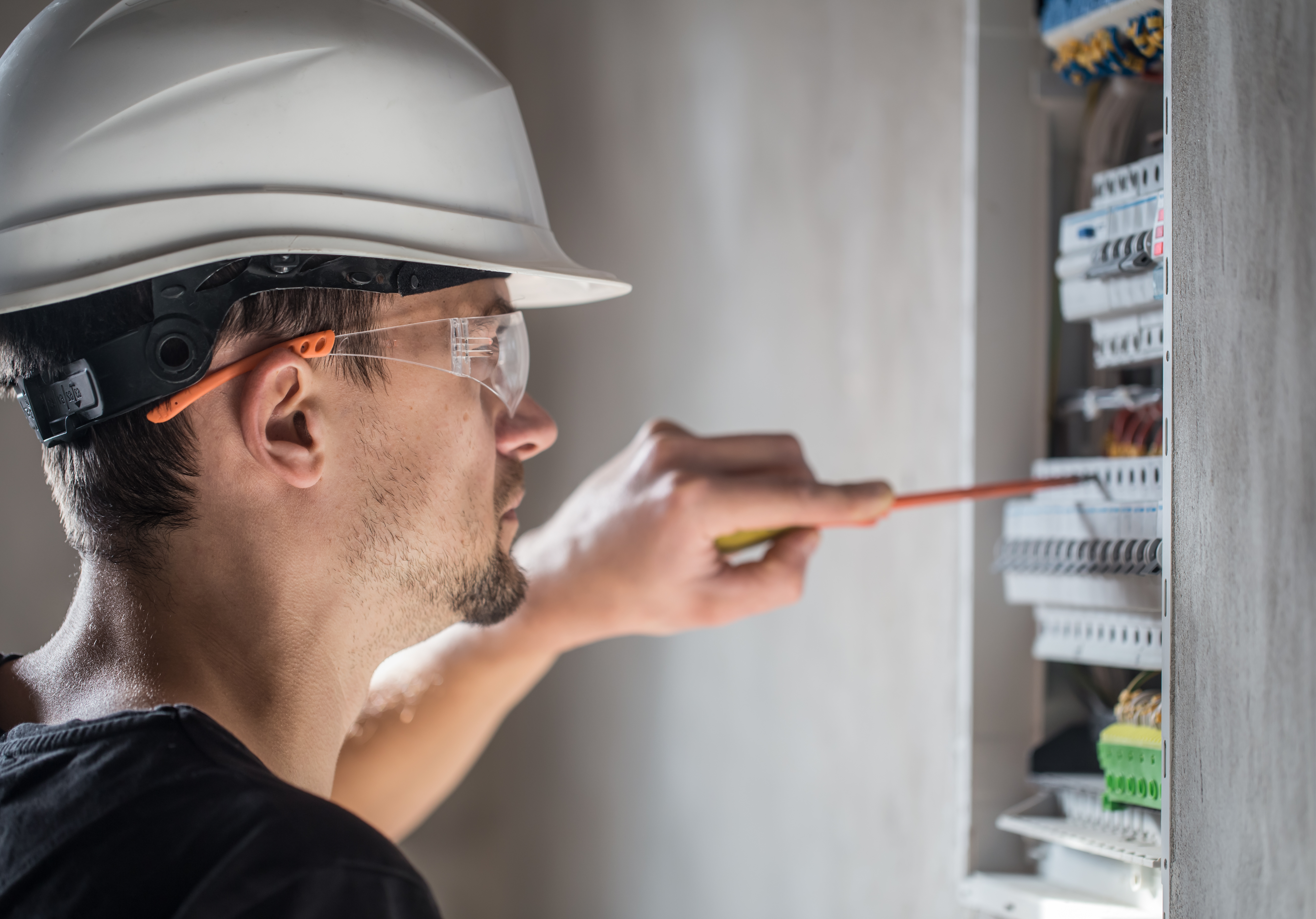 man-electrical-technician-working-switchboard-with-fuses-installation-connection-electrical-equipment-close-up.jpg