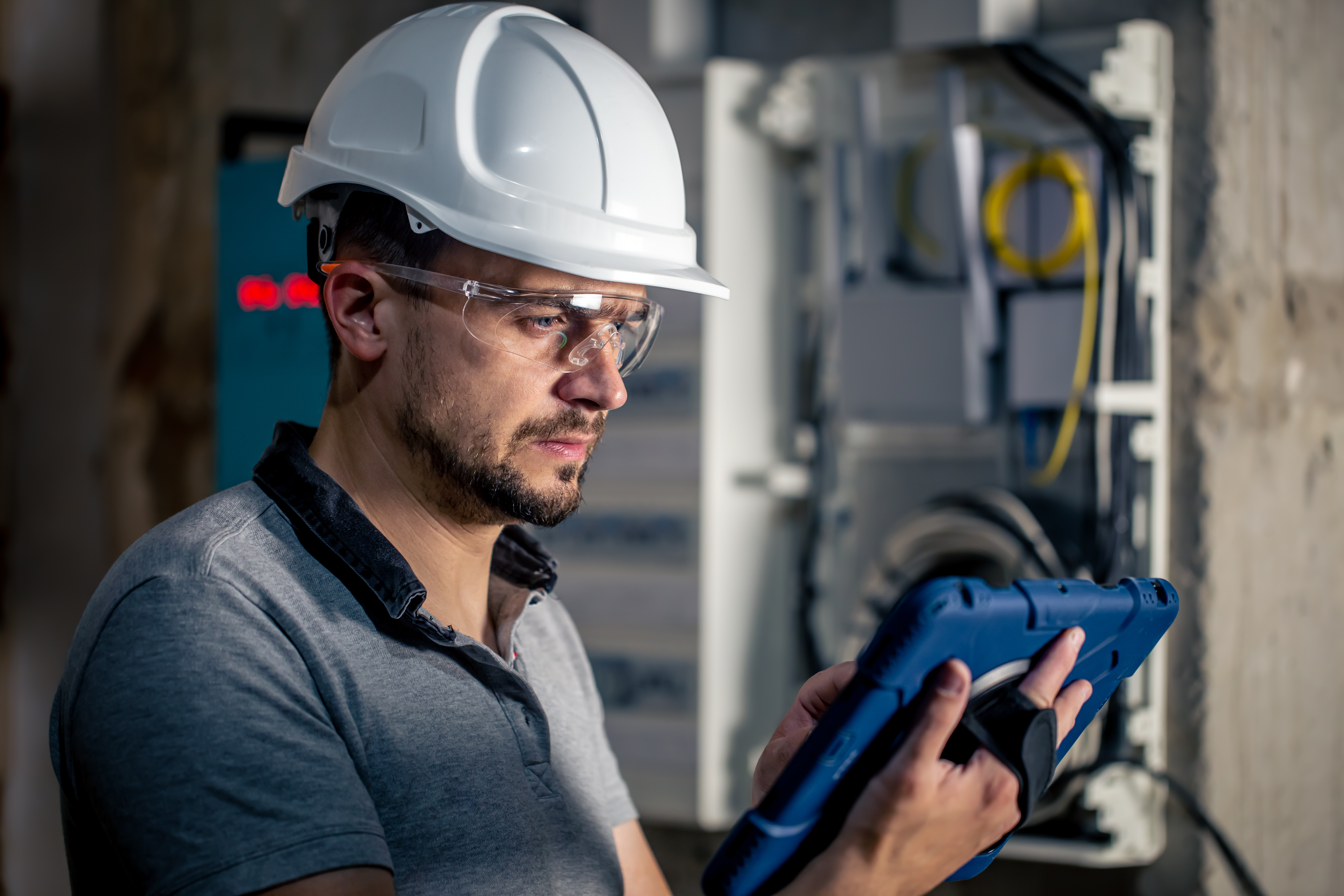 man-electrical-technician-working-switchboard-with-fuses-uses-tablet (1).jpg