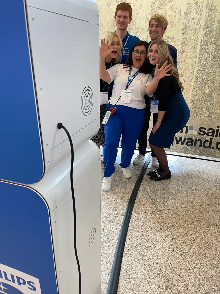 Gäste mit Namensbändern feiern vor der Fotobox