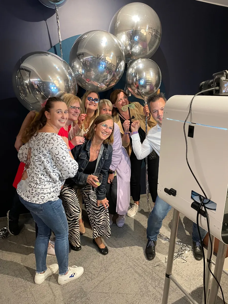 Gruppe mit silbernen Ballons posiert vor der Fotobox