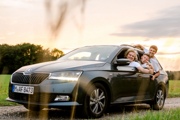 3 Fundraiser schauen grinsend aus dem Auto und fahren von ihrem Ferienjob zurück