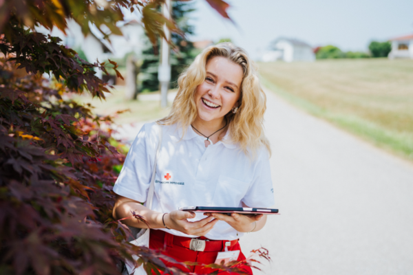 Eine lächelnden Fundraiserin unterwegs mit ihrem Tablet