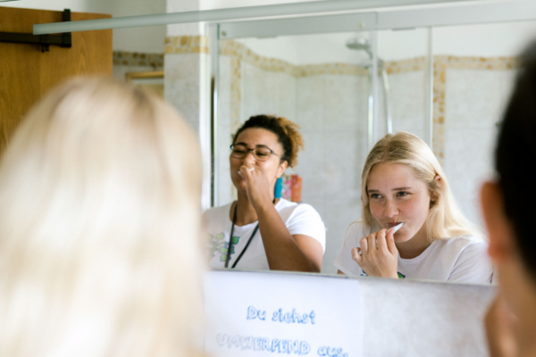 2 Fundraiserinnen die vor dem Spiegel stehen und Zähne putzen