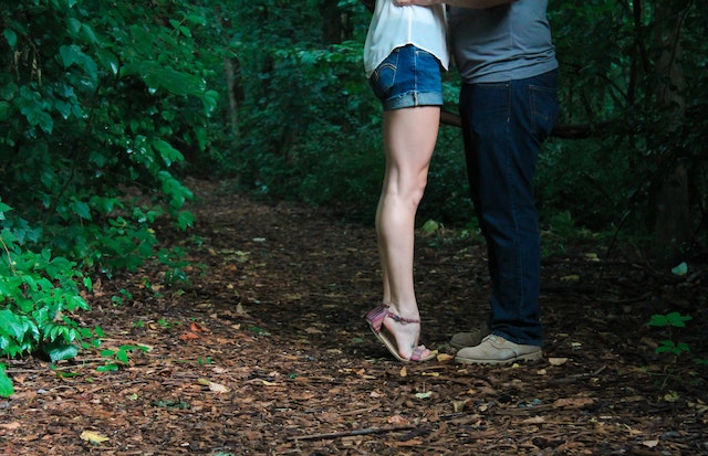 Mann und Frau küssen sich im Wald