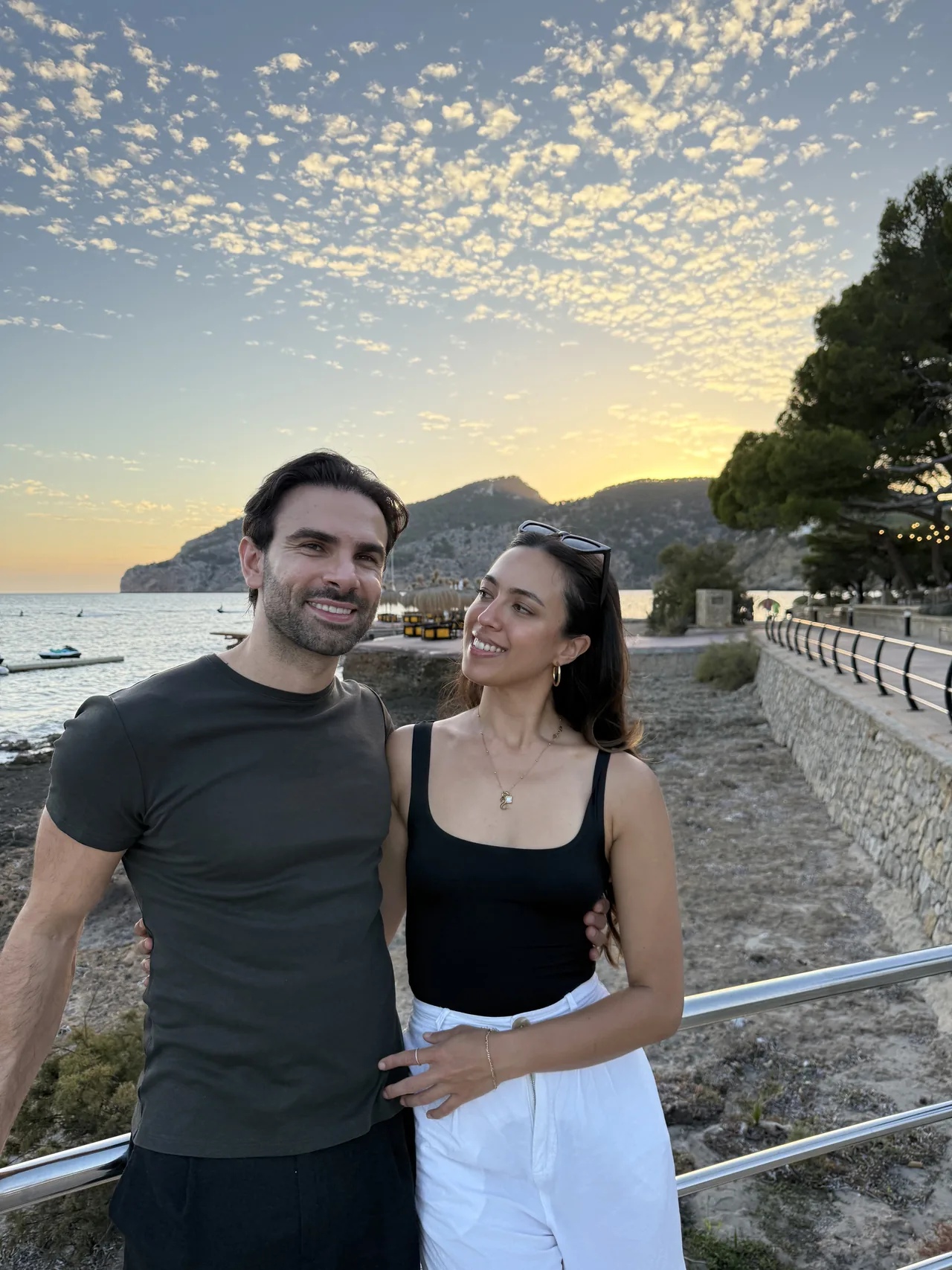 Hendrik Fuchs und Stephanie stehen gemeinsam an einer Küste im Abendlicht.