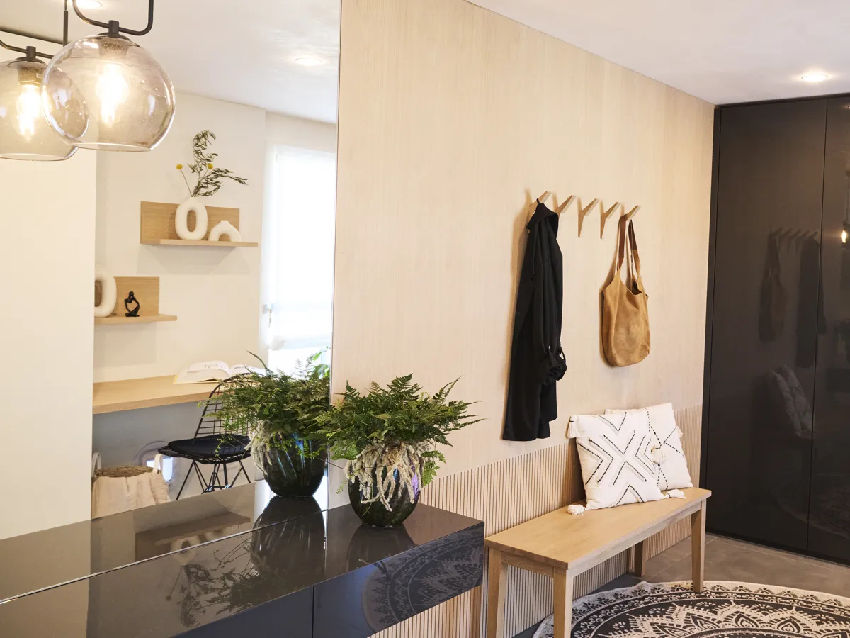 Eingangsbereich mit heller Holzwand, Garderobe und Sitzbank, ein Projekt von INKONTEXT