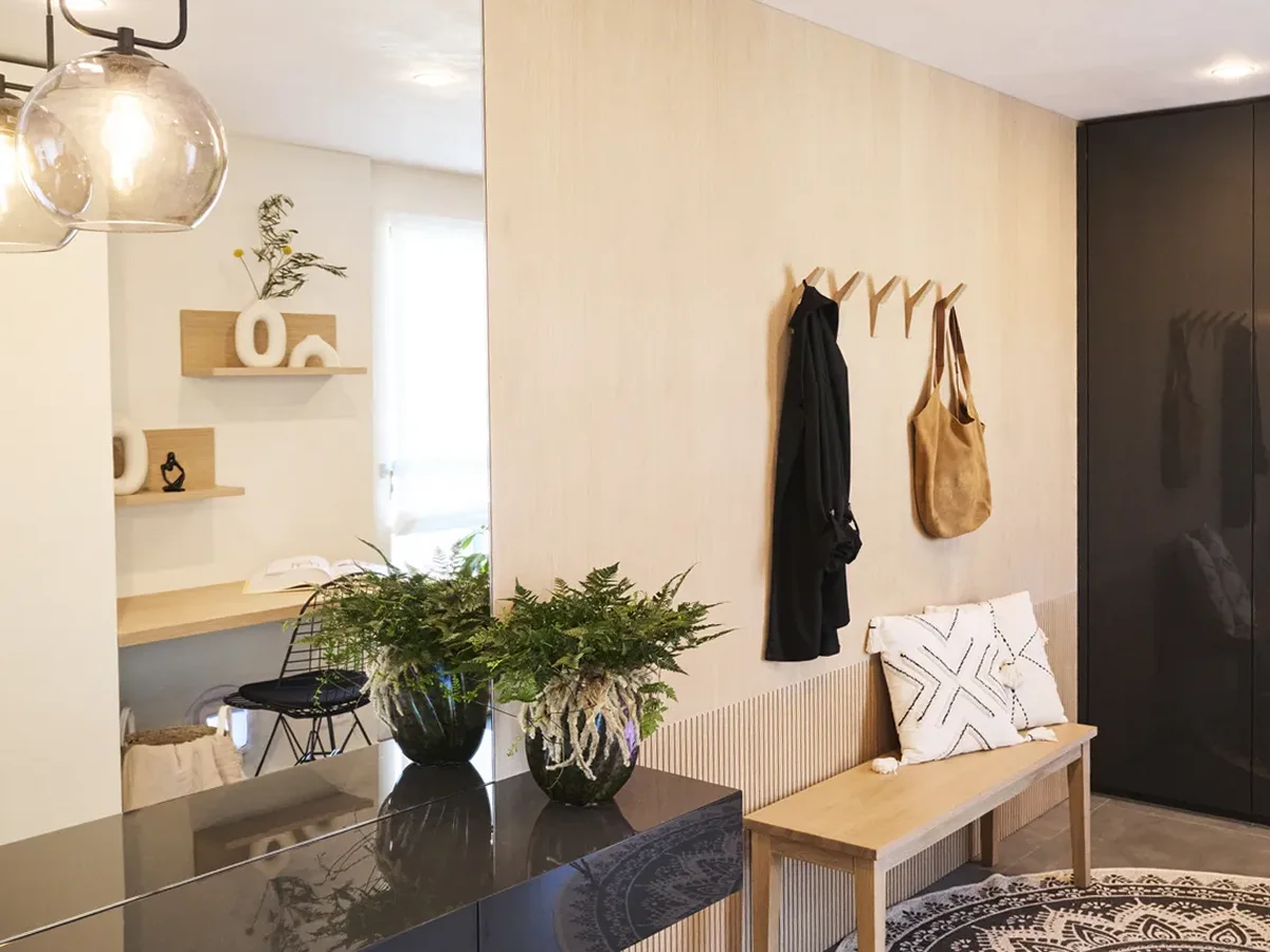 Eingangsbereich mit heller Holzwand, Garderobe und Sitzbank, ein Projekt von INKONTEXT