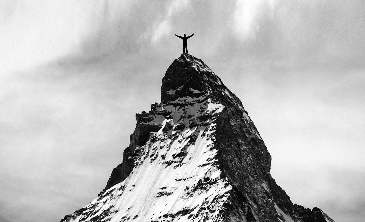 Mann steht auf dem Berg des Erfolgs