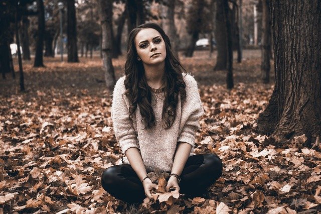 Frau mit Herzschmerz im Wald