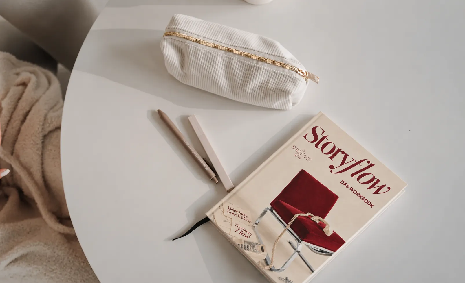 Das Storyflow-Workbook liegt mit Stiften und einem cremefarbenen Etui auf einem hellen Tisch.