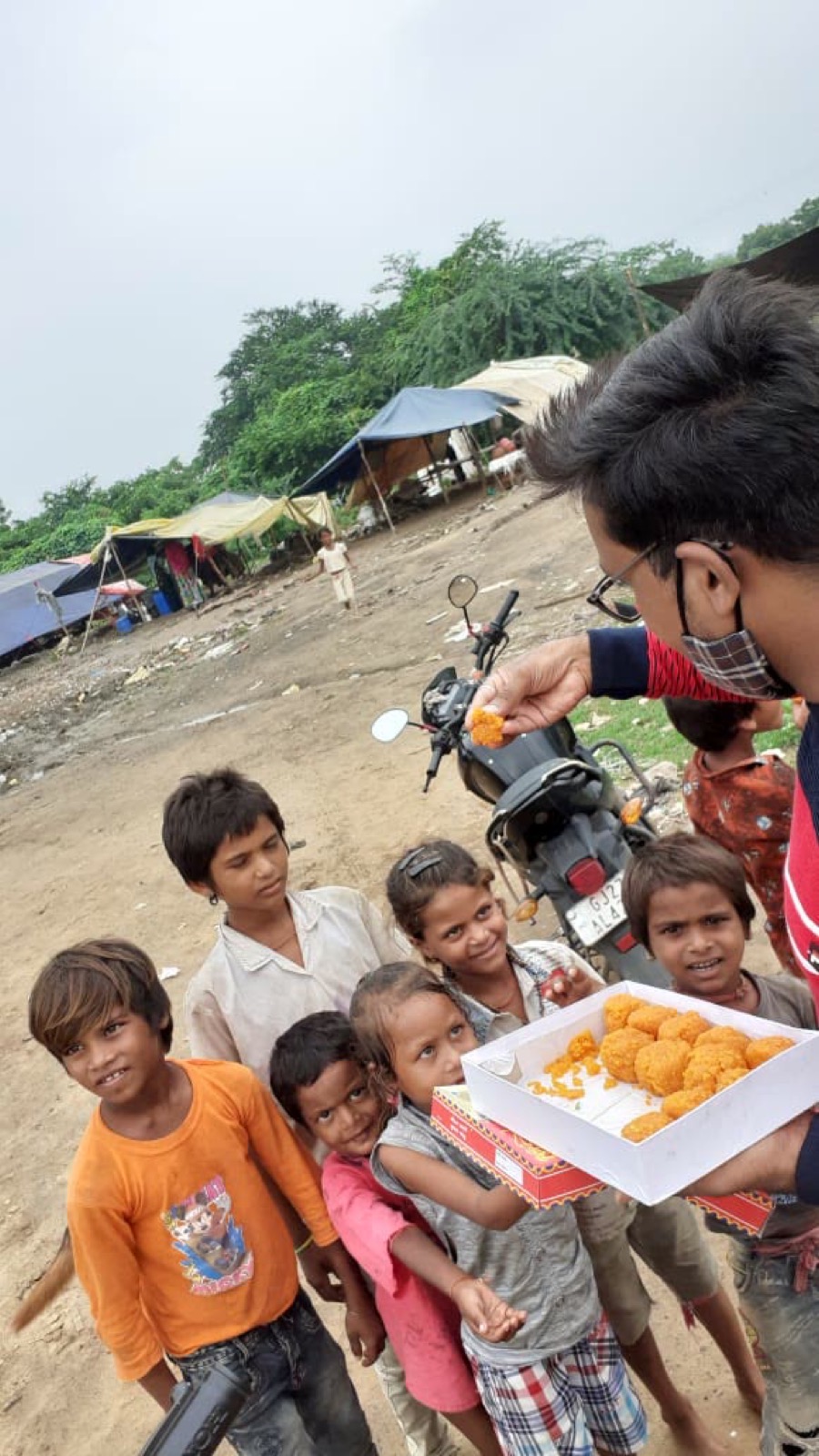 A UUF volunteer handing a prepared meal to a community member