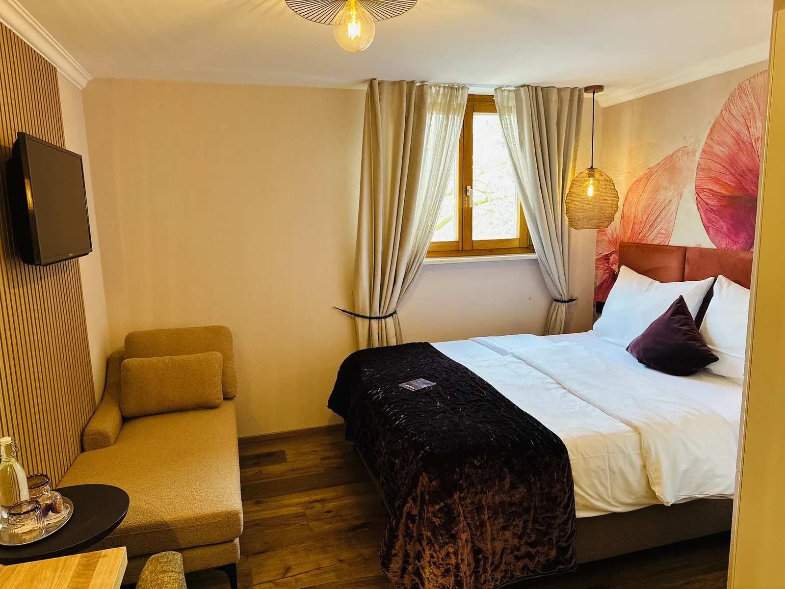 Komfort Doppelzimmer mit gelbem Sessel, Tisch und Doppelbett