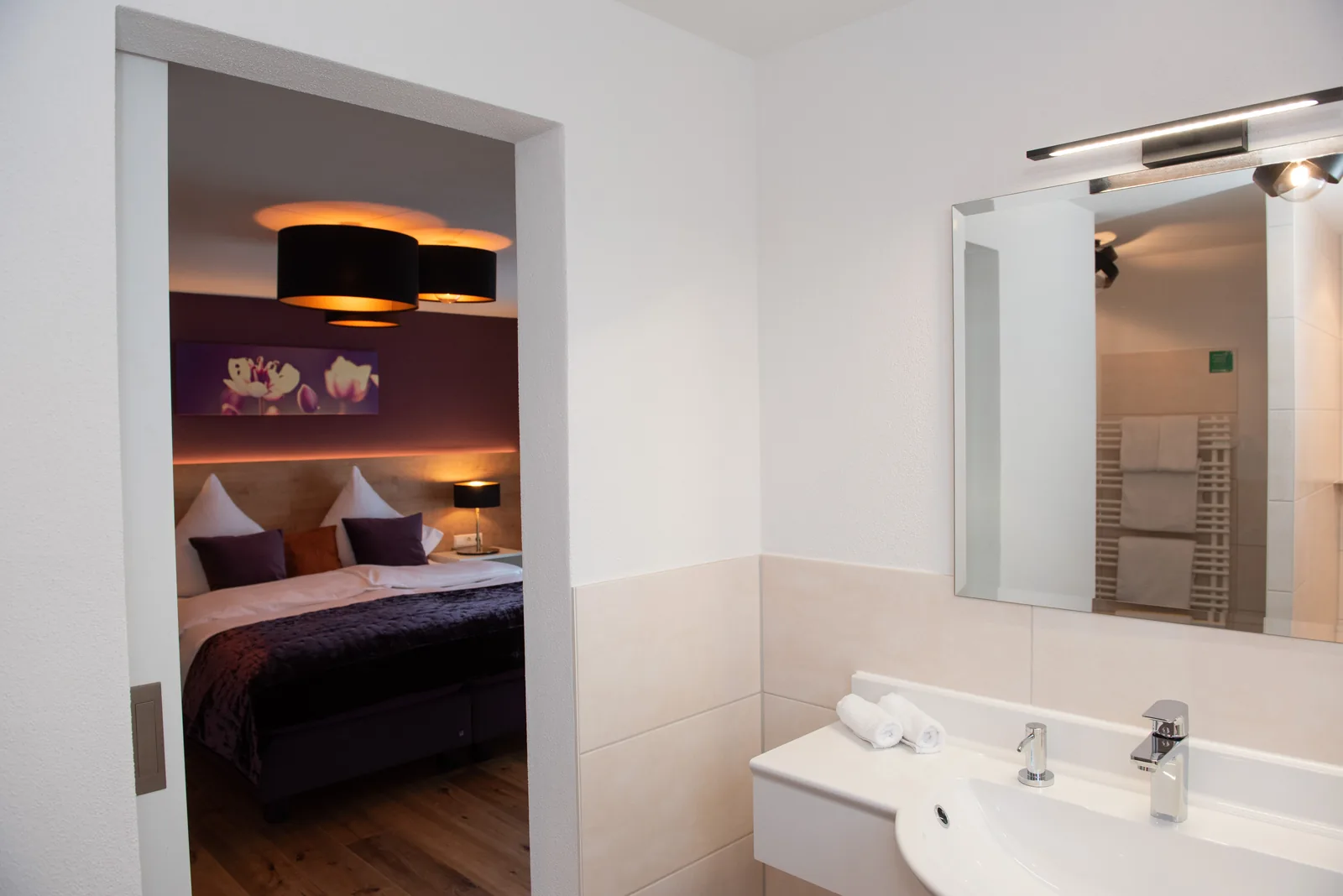Bad mit Spiegel, Waschbecken und Blick ins Superior Zimmer