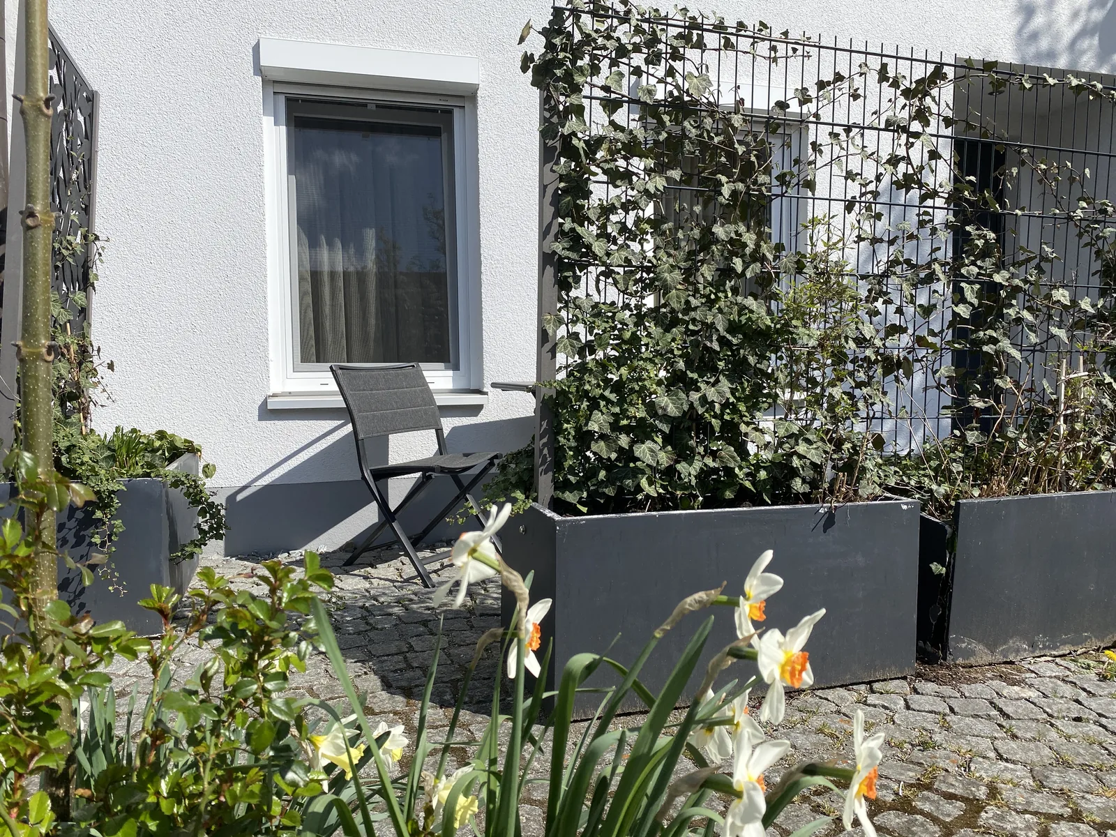 Terrasse der Junior Suite mit Sitzgruppe und blühendem Strauch