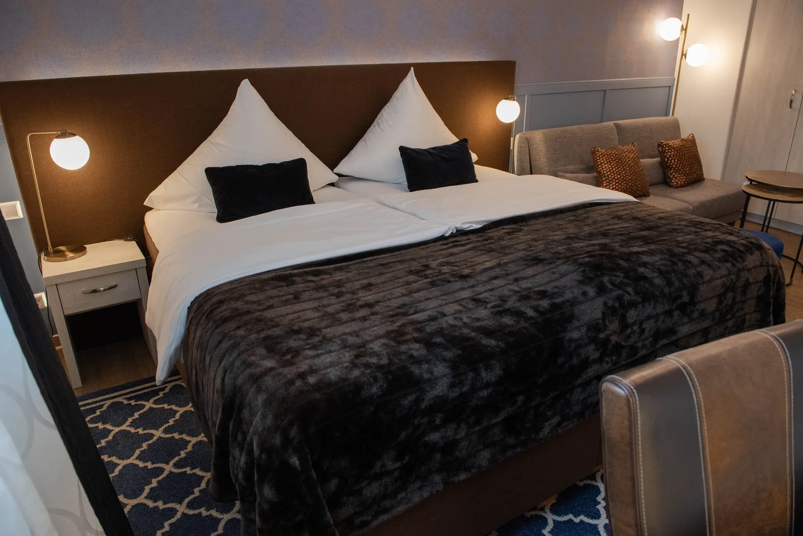 Doppelbett mit dunkler Tagesdecke im Superior Zimmer