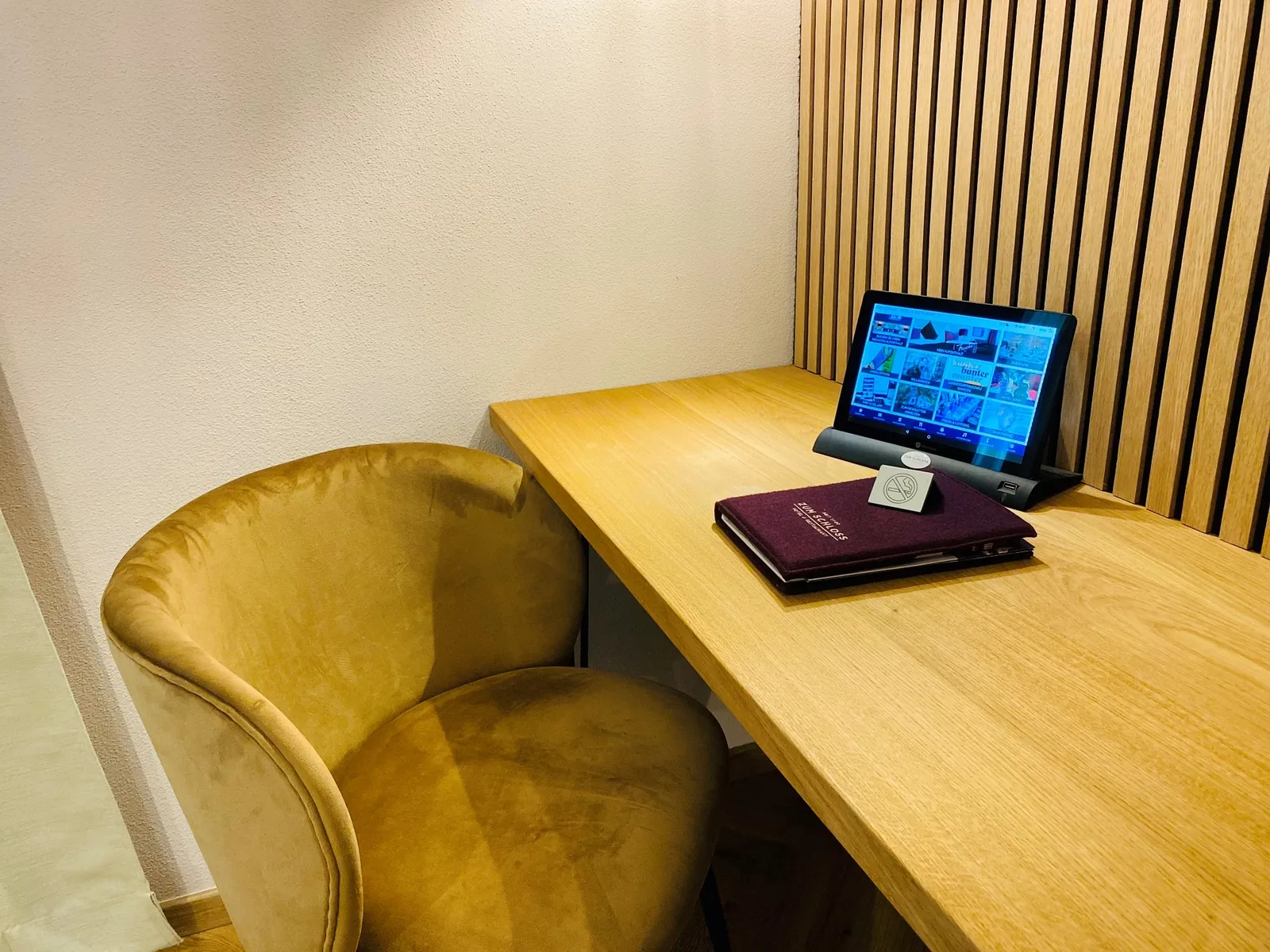Schreibtisch mit Tablet und Samtsessel in der Junior Suite