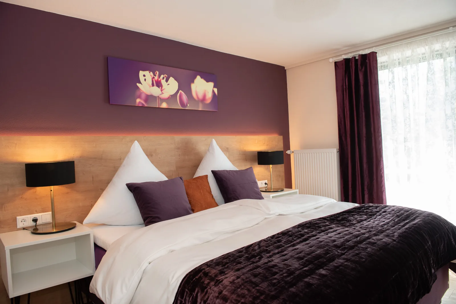 Superior Zimmer mit Doppelbett, dunkler Tagesdecke und violetter Wand