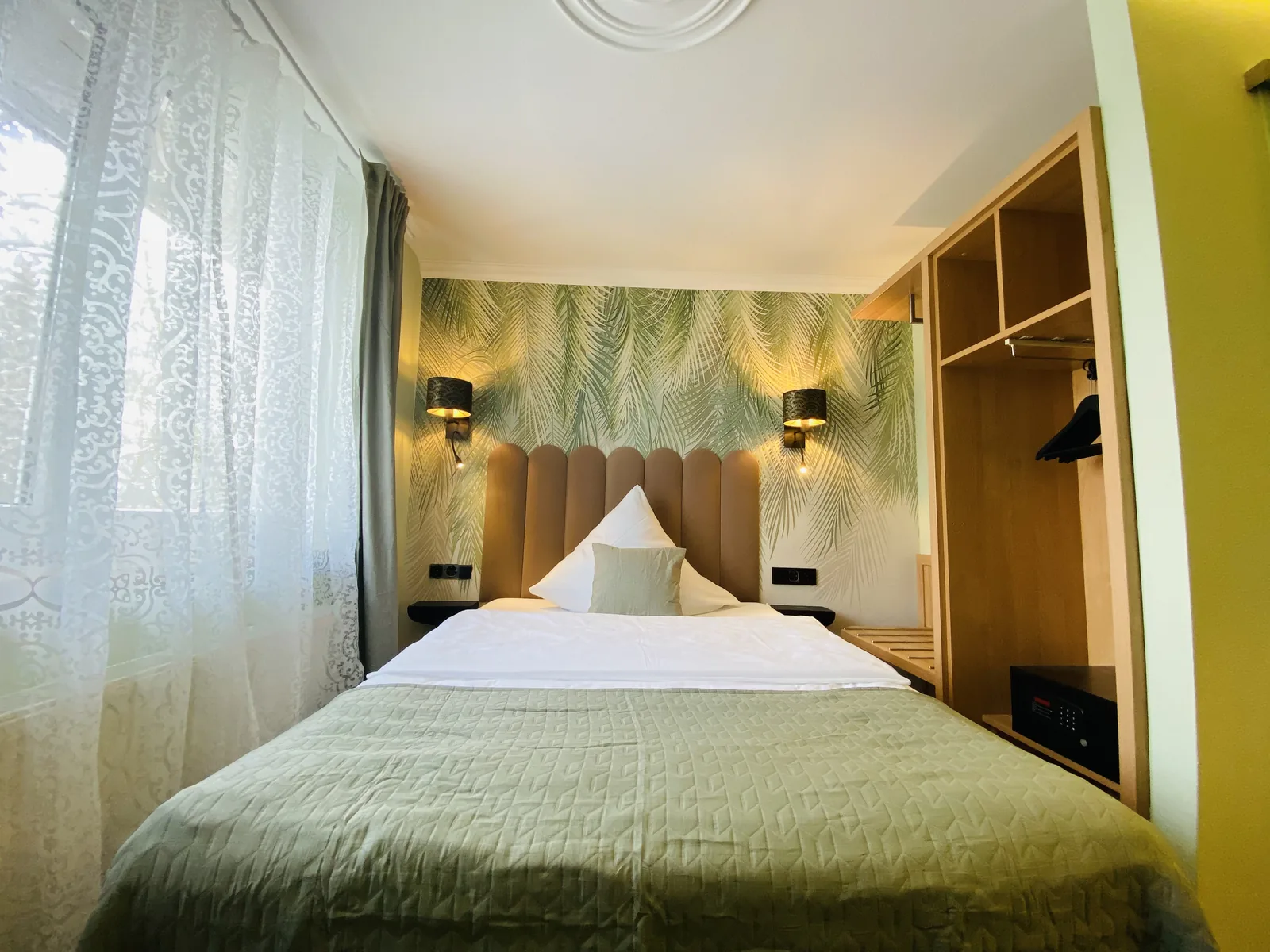 Einzelzimmer Plus mit Doppelbett und grünem Wandbereich
