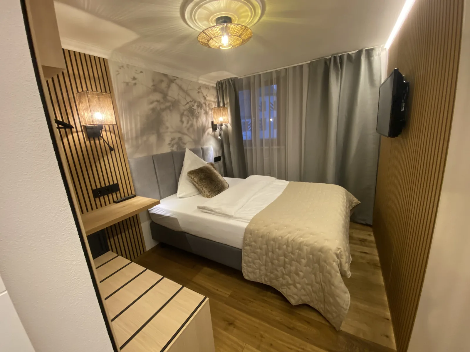 Einzelzimmer Plus mit Bett vor Motivtapete