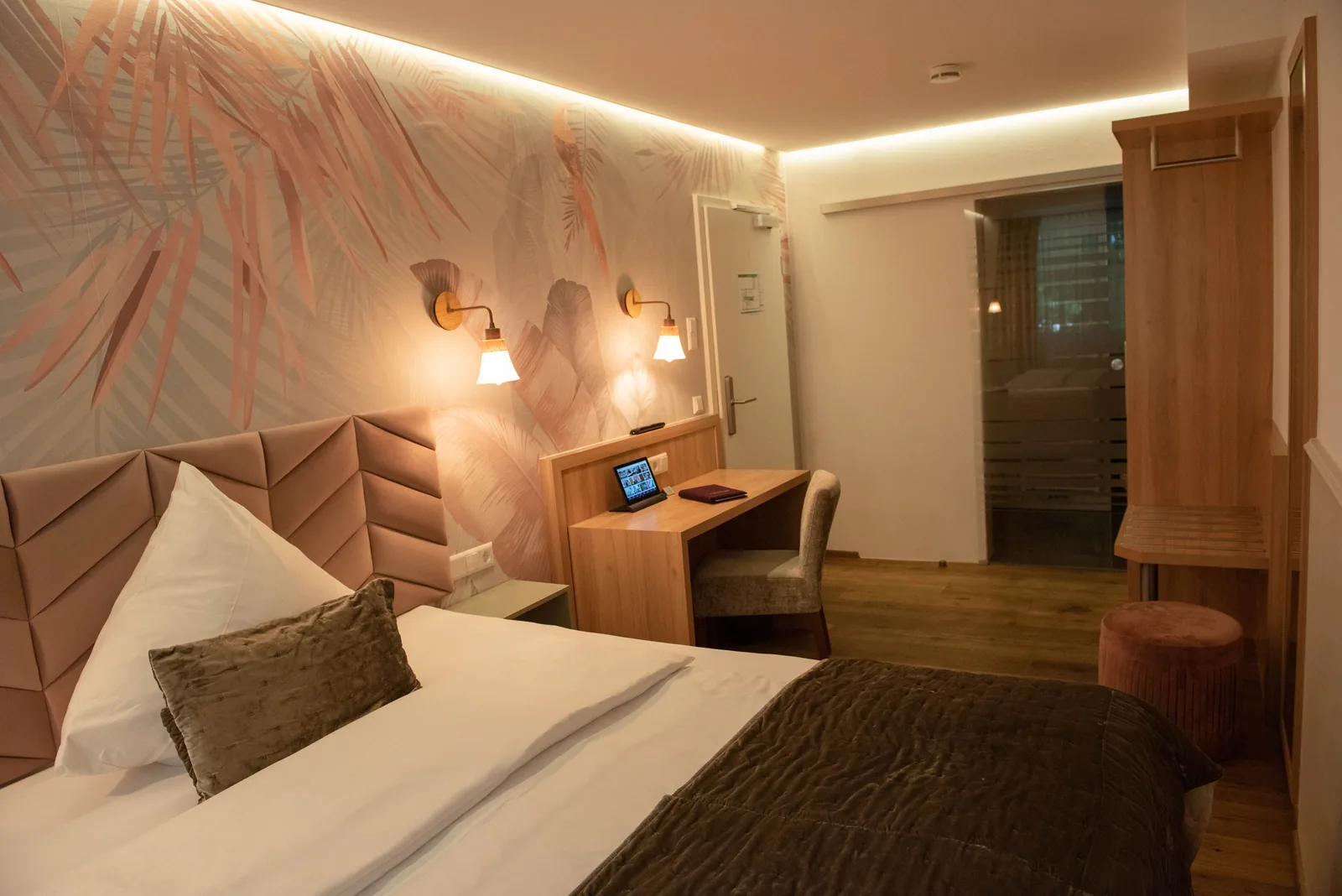 Komfort Doppelzimmer mit Schreibtisch und rosafarbener Wandgestaltung